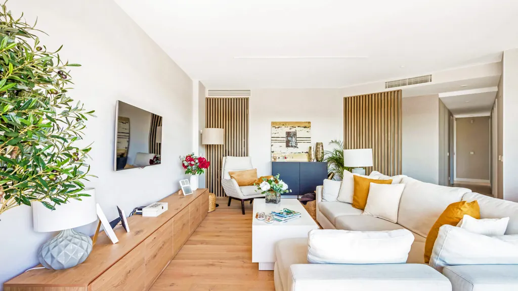 Salón con sofás claros y cojines turquesa en una vivienda de nueva construcción