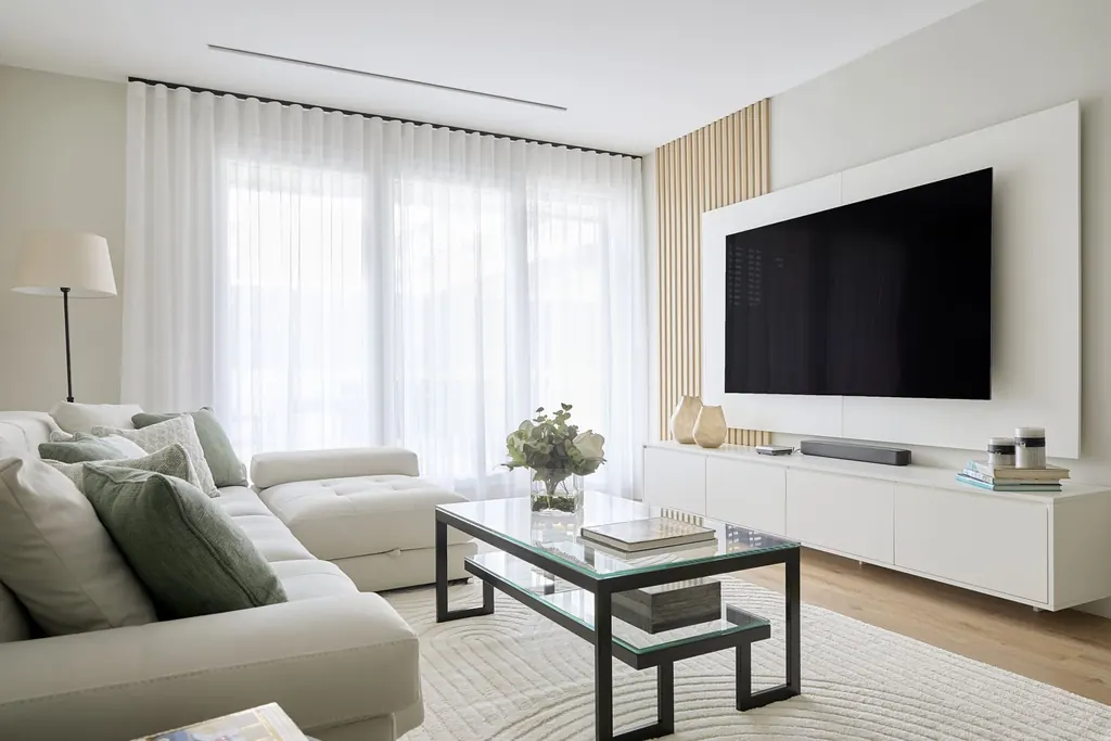Salón con sofá blanco, cojines y mesa de centro